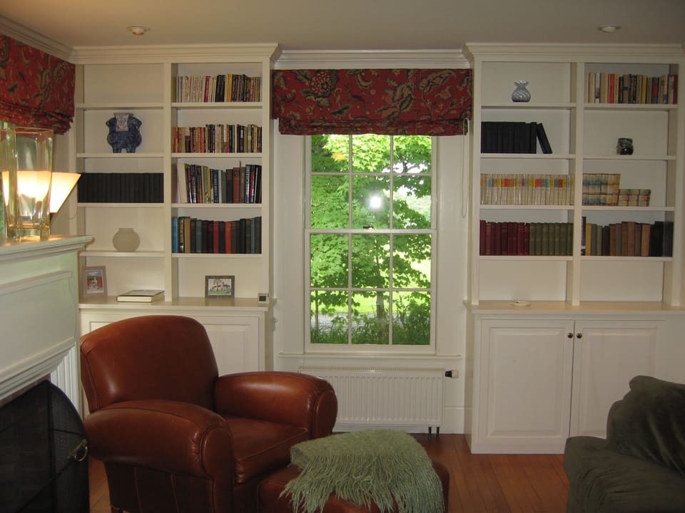 Annex Living Room with Leather Reading Chair and Wood-burning Fireplace.