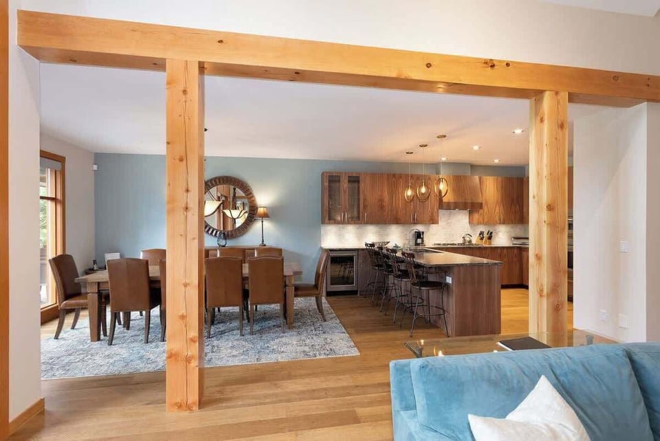 - Bright open layout connecting dining room and modern kitchen space  
- Wooden beams and soft blue tones create a warm, stylish atmosphere  
- Great for family meals or social gatherings with effortless flow  
