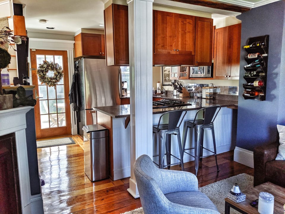 Living room looks into kitchen with private outdoor space 