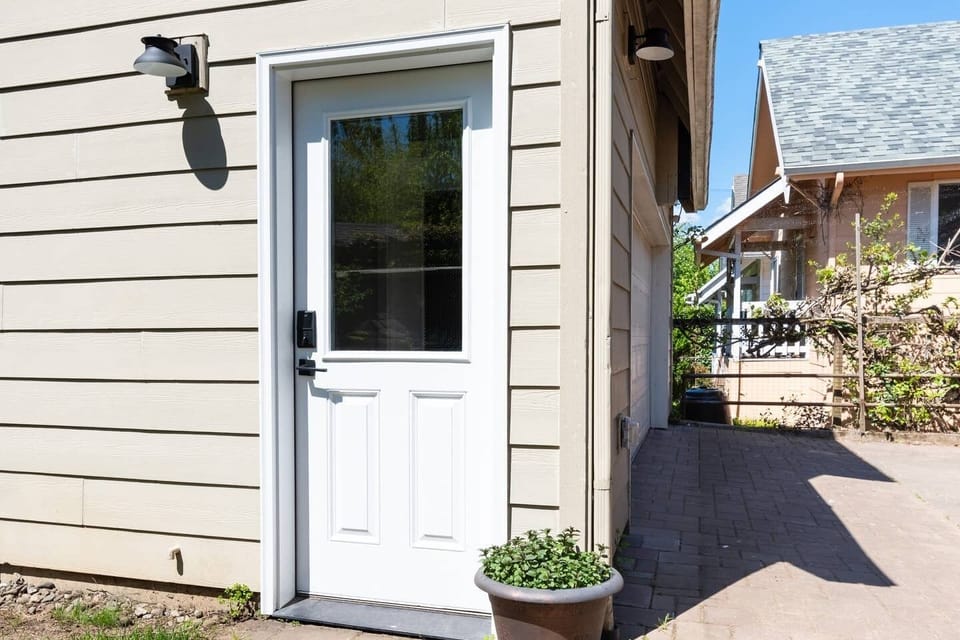 Lighted driveway leads to entrance door with keyless deadbolt lock.