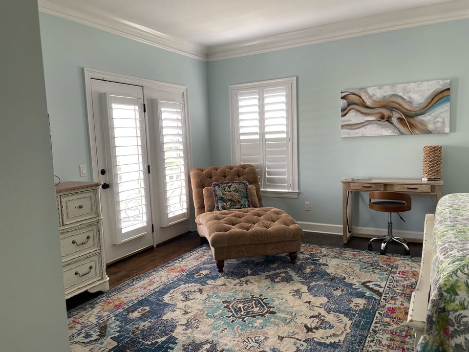 Mstr has large screen TV, large dresser, door that leads to around porch