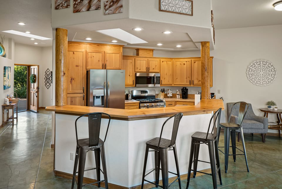 The bright kitchen features bar seating and a stocked Keurig coffee station.