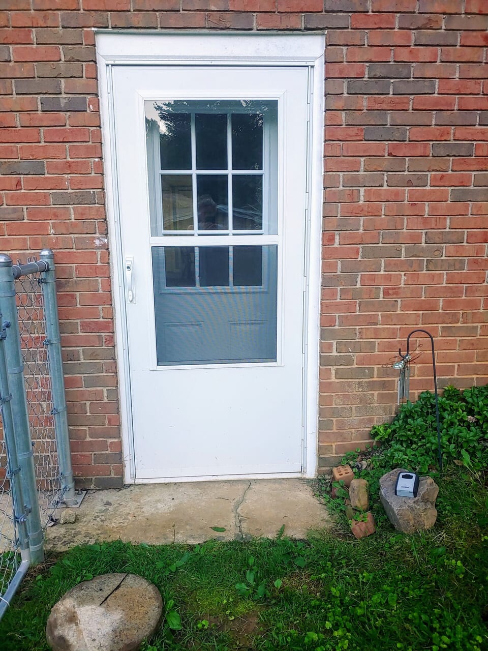 The lockbox sits on the rock to the right of the door.