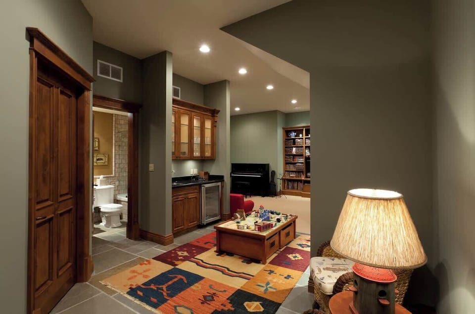 - Cozy game lounge with warm lighting, soft rug, and mini bar setup for relaxing nights  
- Perfect family area featuring board games, comfortable seating, and entertainment space  
- Inviting lower-level retreat ideal for unwinding after a day 