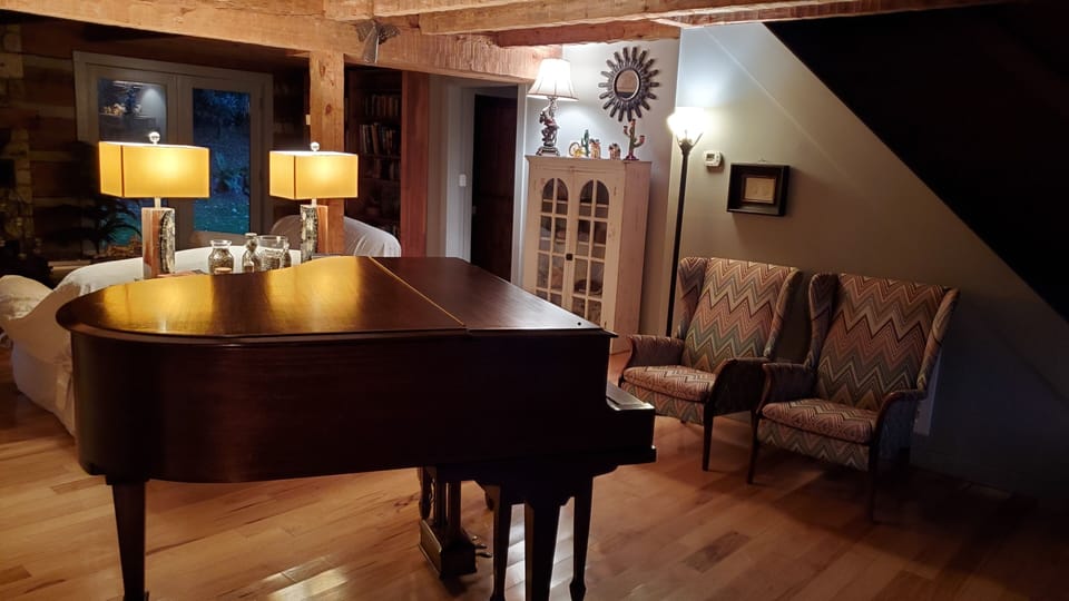 Baby grand piano behind living room sitting area