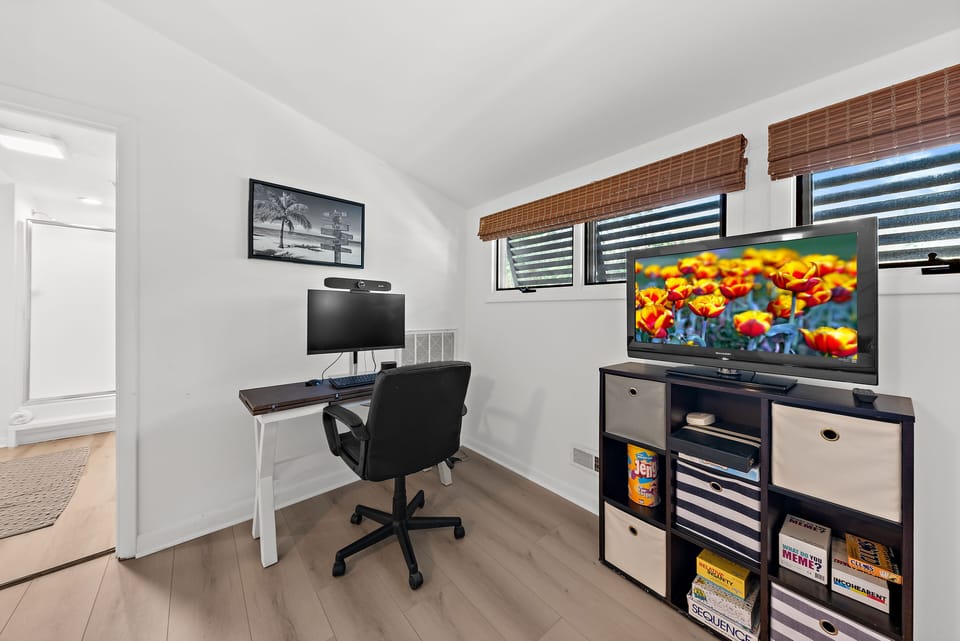 A desk with monitor and a large Smart TV.