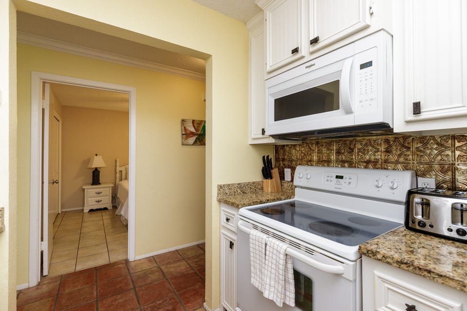 Your fully equipped kitchen features granite counters, ornate backsplash, and all modern appliances for easy home-cooked meals.