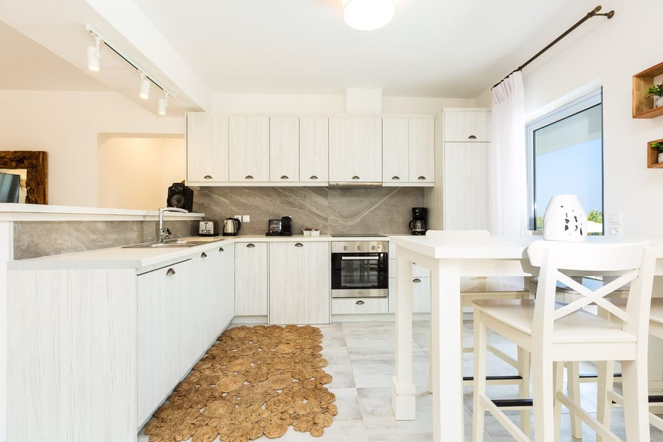 Fully equipped kitchen with branded appliances and breakfast counter.