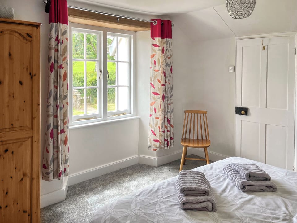 Bedroom 1 with views over garden | Well Farmhouse - Well Farm Holiday Cottages, Holsworthy, near Launceston