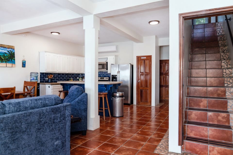 Entry with family room and kitchen to the left, stairs to second floor, main 1st floor king bedroom to the right