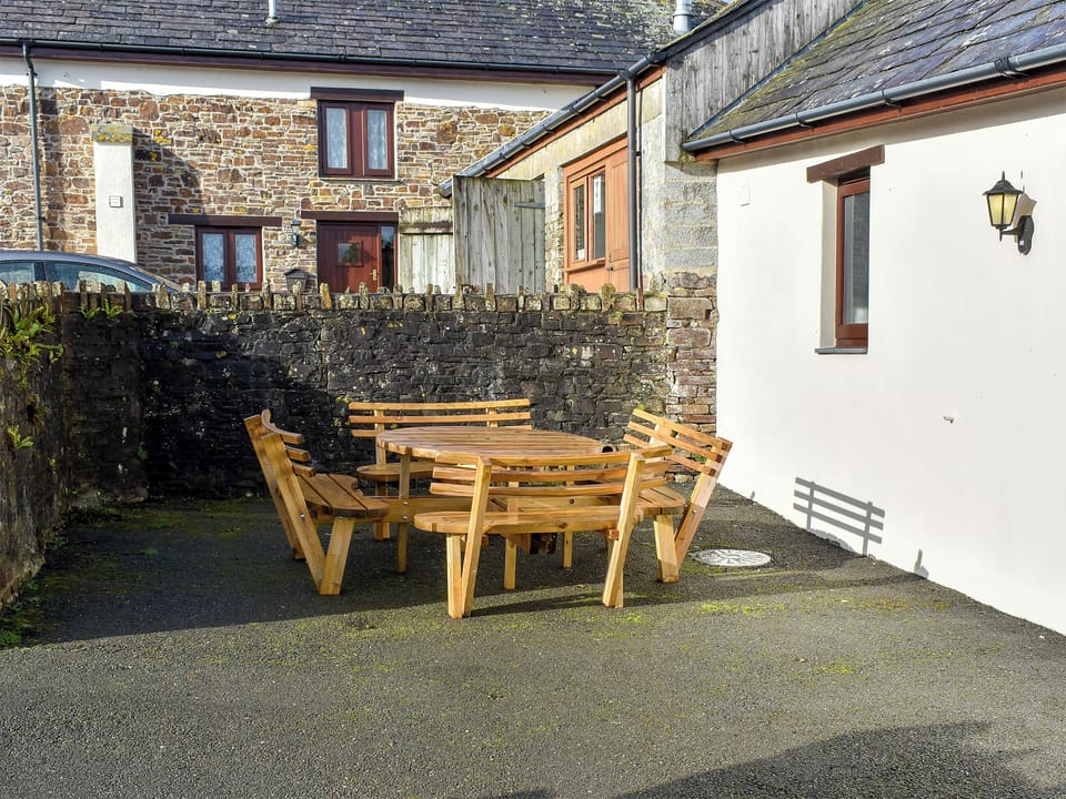 Private courtyard with garden furniture | Trewin Court - Well Farm Holiday Cottages, Holsworthy, near Launceston
