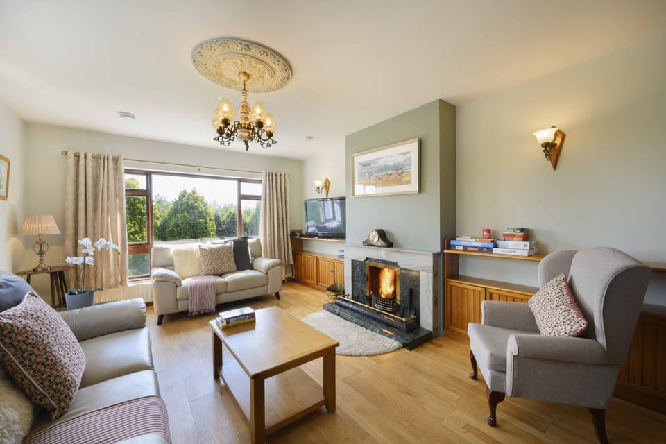 Living room with comfy sofas, chairs and cosy fire for colder days