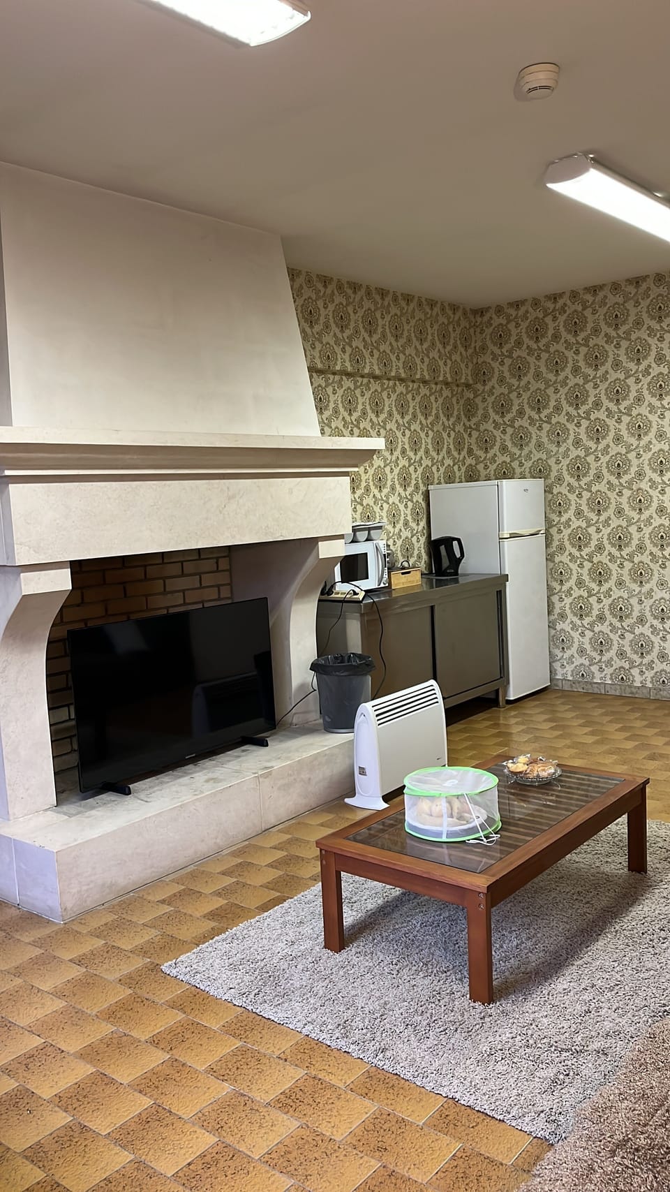 In the guest lounge you can see a basic kitchen area with a fridge and microwave