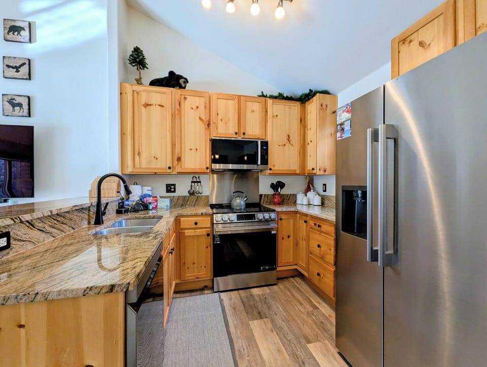 Your fully equipped kitchen features beautiful stone countertops, stainless steel appliances, and cozy rustic charm for preparing meals together.