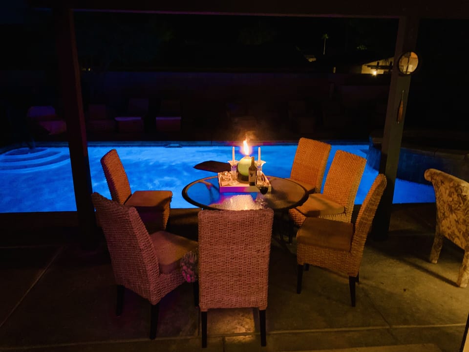 Evening poolside outside dining with a beverage.
