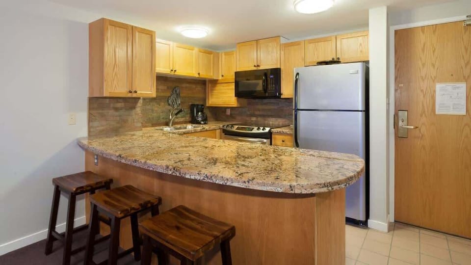 - Modern kitchen with granite countertops and wood cabinets  
- Fully equipped for long stays and family dining comfort  
- Enjoy home style meals in a Whistler vacation rental  
