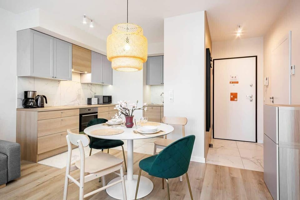 A cozy dining and living space with modern furniture, a neutral color palette, and large windows for natural light.