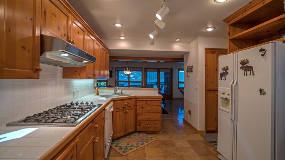 Kitchen has a breakfast bar, seating for 3. hallway to right leads to laundry rm