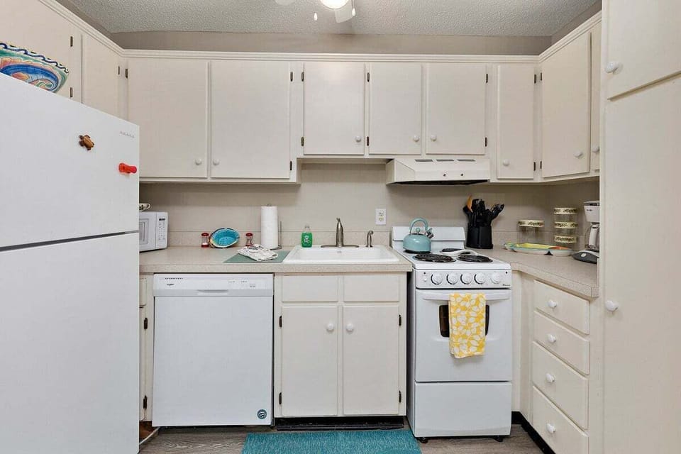 White kitchen with white appliances and tile floors