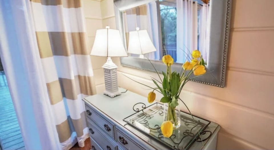 The master includes nicely appointed furniture including a dresser and nightstands with lamps.