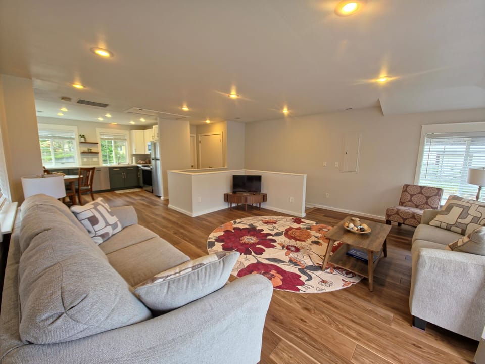 Relax in your spacious open-concept living area with plush seating, warm hardwood floors, and seamless flow to your fully-equipped kitchen.