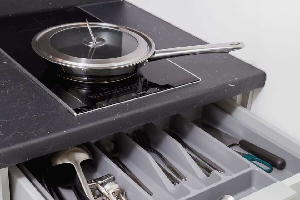 A closer look at a kitchen stove with a pull-out drawer below it. The stove is modern and features a sleek black surface.