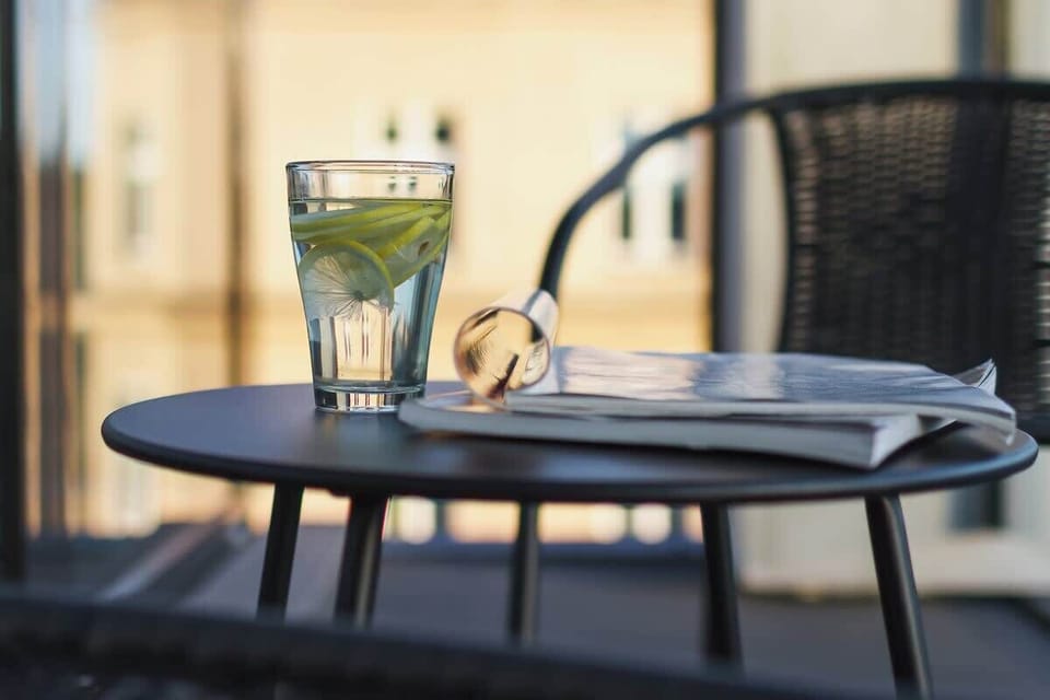 A small round table on the balcony with two chairs, ideal for enjoying morning coffee. The view overlooks the city, providing a relaxing outdoor space.