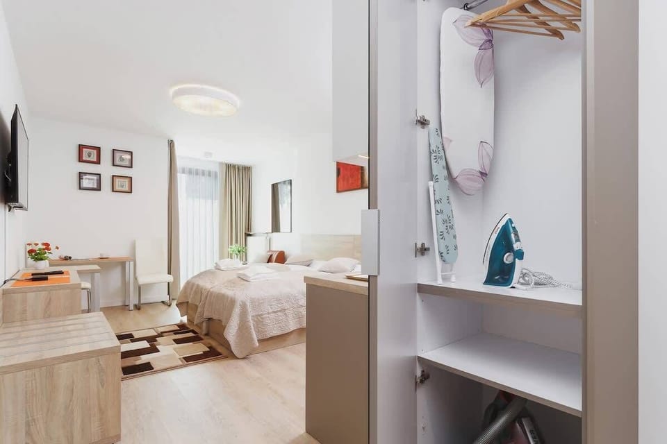 A tall wardrobe with sliding doors, placed near the entrance. In the background, the living room is visible, featuring a stylish sofa and decor.