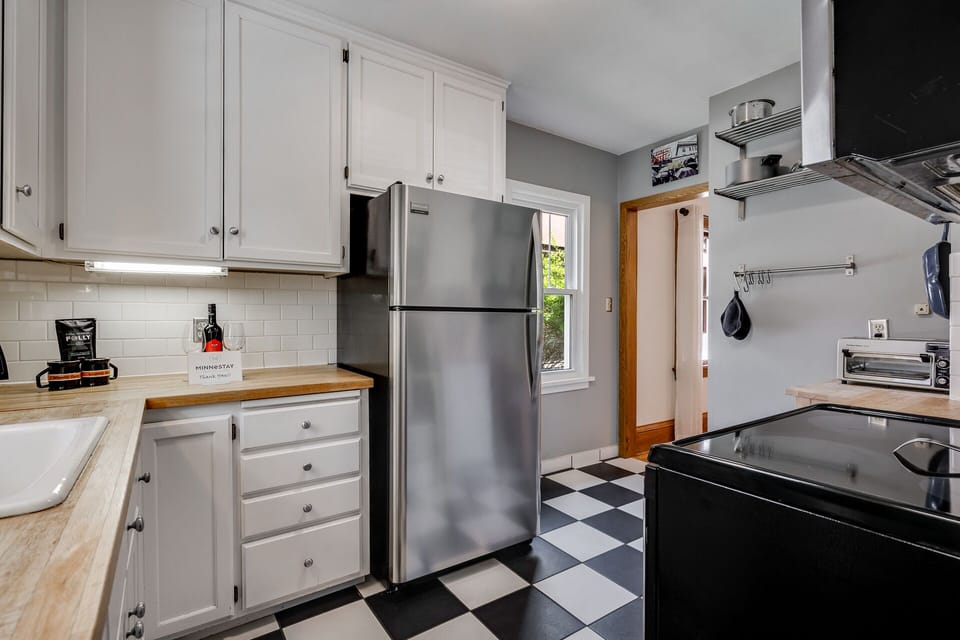 Cook your favorite meals in this bright, fully equipped kitchen with stainless steel appliances and classic checkered floors.