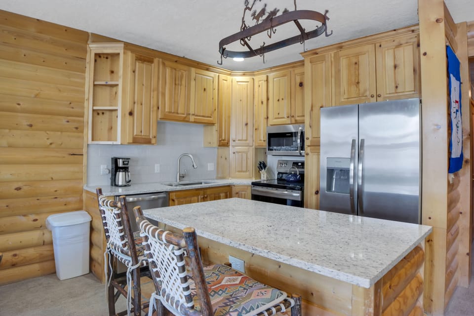 Comstock 203 offers a well equipped kitchen with stainless steel appliances, wood cabinets and island with seating for two.