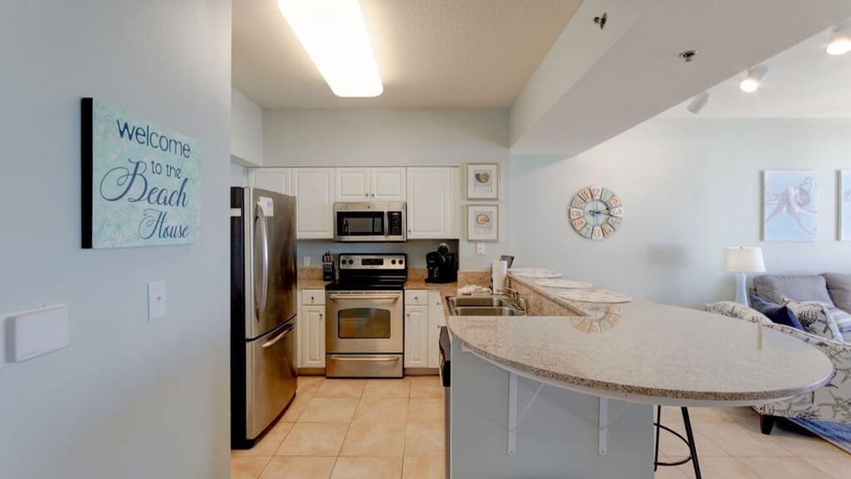 Granite counters and stainless appliances in the fully stocked kitchen