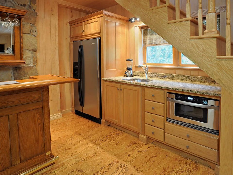 Custom cherry kitchenette with granite counter top, solid oak bar in Game Room.