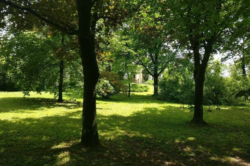 La maison vue du parc, assis sur un banc, un livre à porté de la main