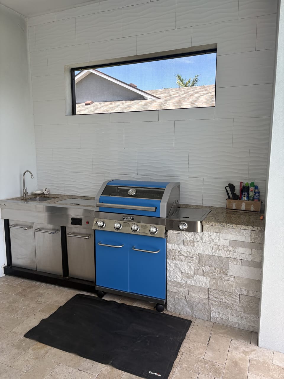 Outdoor kitchen with built-in grill, sink, and cooler