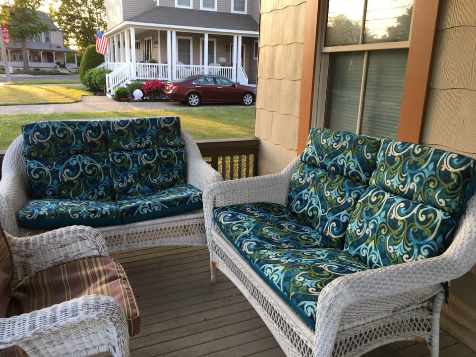 Front covered porch with wicker furniture.