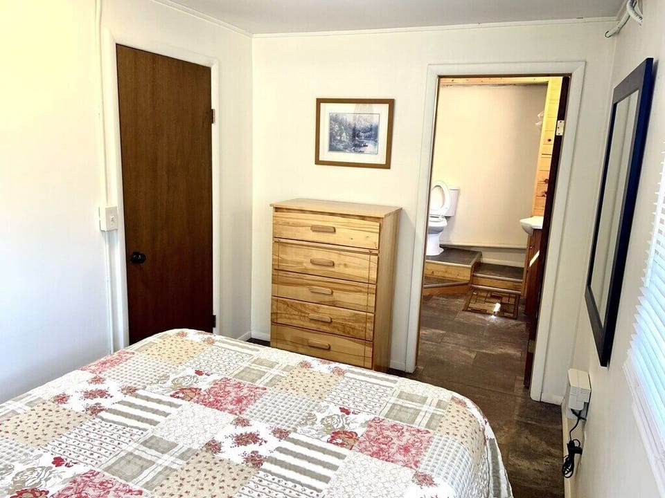 Bedroom with dresser and private entrance to bathroom 