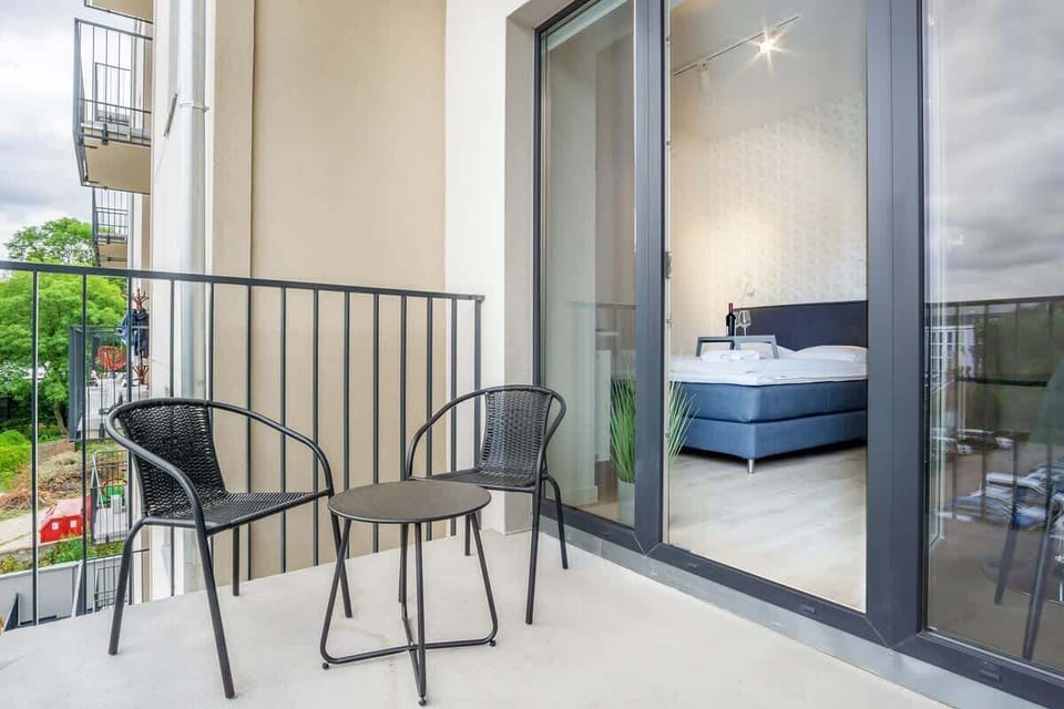 A private balcony with a small table and two chairs, perfect for enjoying a coffee or reading in the fresh air with a view of the surrounding area.