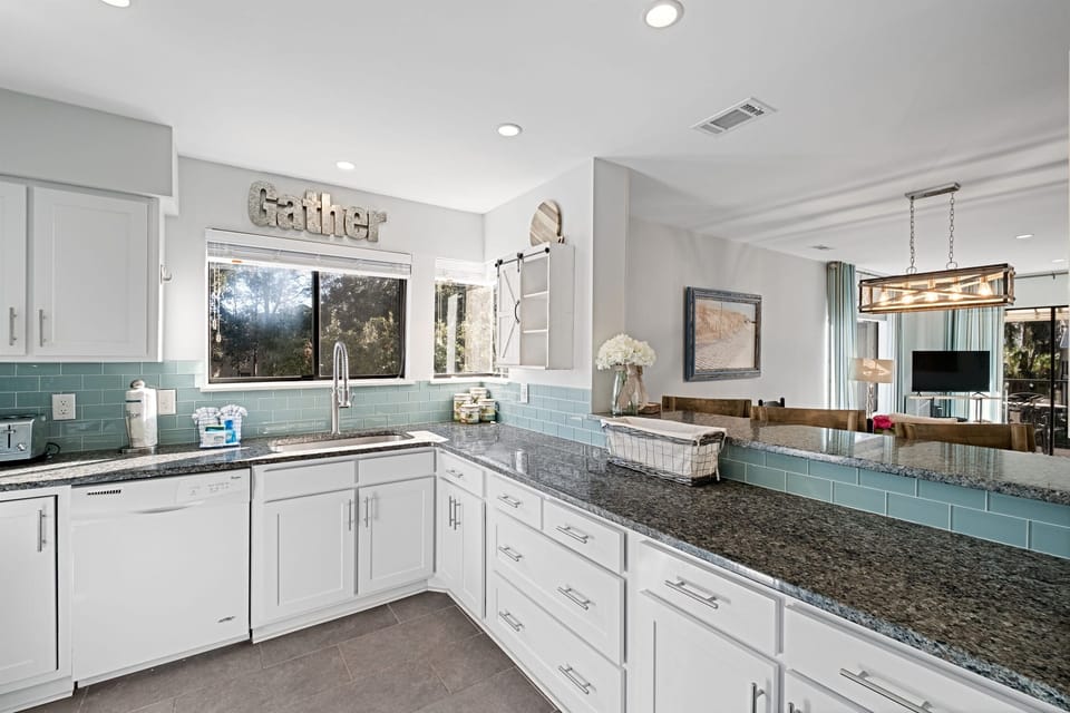 Whip up Lowcountry feasts in this bright, fully equipped coastal kitchen with granite counters, deep sink, and plenty of space for prepping fresh seafood or morning coffee, flowing seamlessly to dining and balcony views in your Hilton Head Island villa.