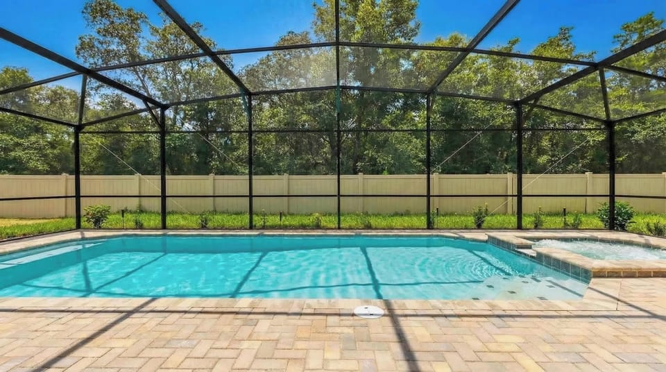 Screened-in pool and spa with serene forest views—pure relaxation!