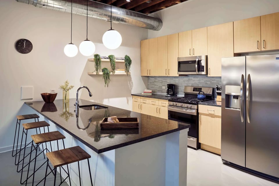 Gourmet kitchen with gas range, stainless appliances, and granite island