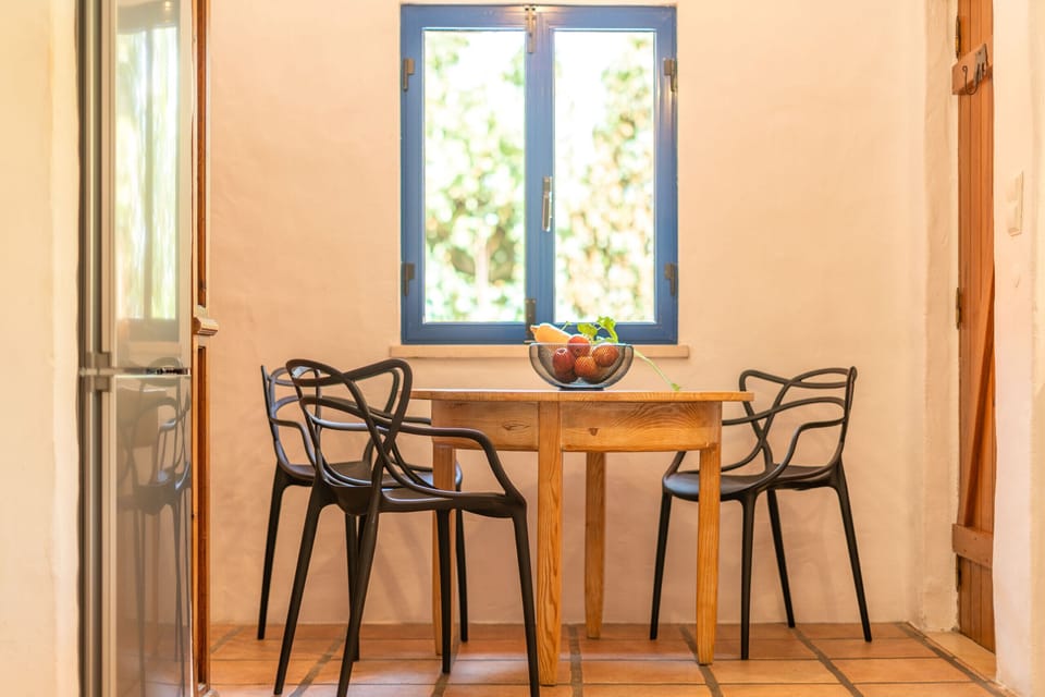 Bright dining nook with wooden table and black chairs — Villa Bambu, holiday villa in Herdade de Aroeira