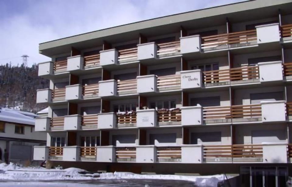 Exterior winter view. South side of the apartment house Chesa Derby with outside parking. swissme holiday stmoritz