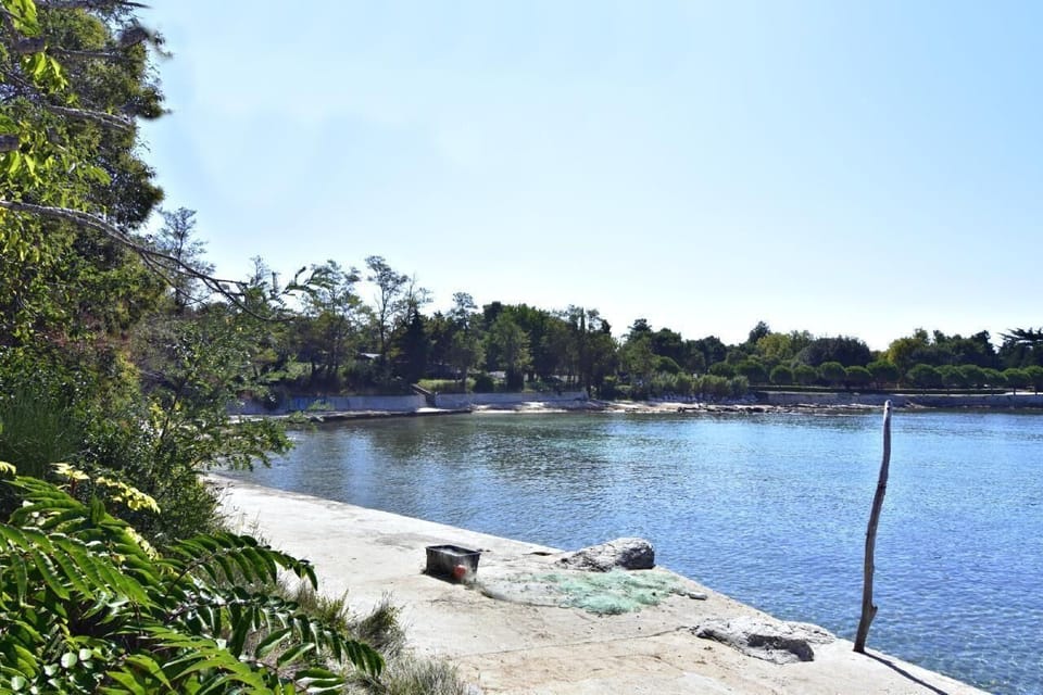 The concrete beach with clear sea and fishermen's nets on the shore of Ravna Dolina