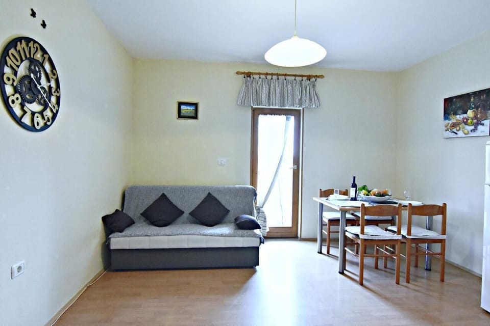The living area with a sofa bed for two people, a dining table and 4 chairs