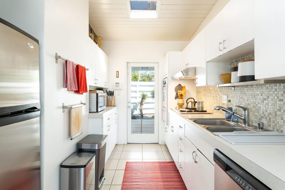 galley kitchen with door to back patio, gas BBQ grill and wash/dryer