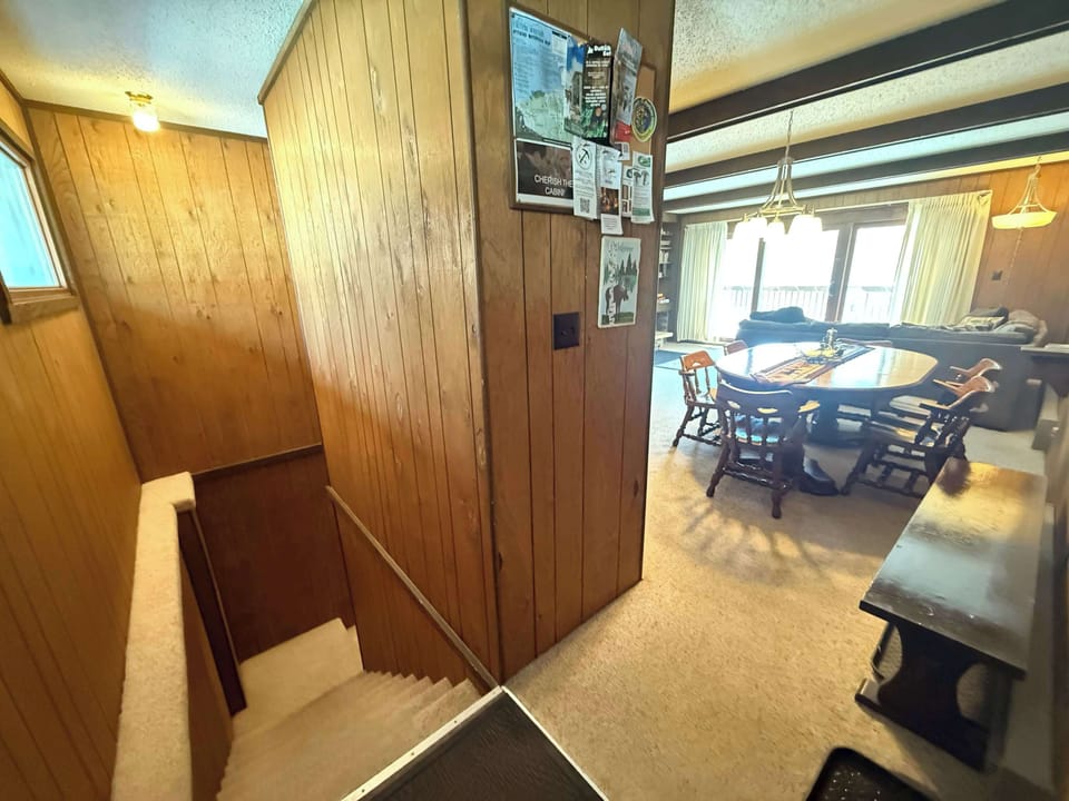 Entryway bench and boot tray - Stairs lead down to bedrooms and sauna from entry