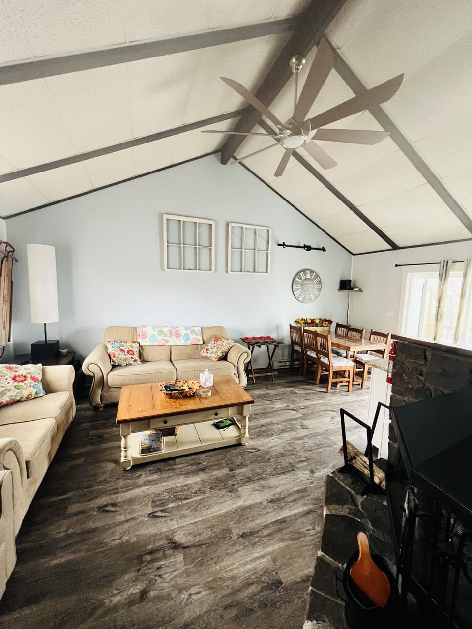 View of the living room (with a wood burning fireplace) and dining area.