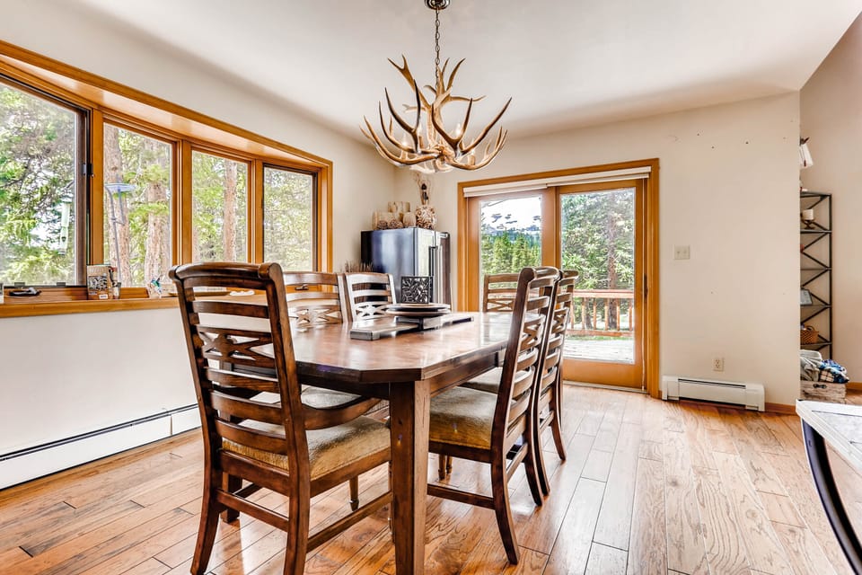 The dining room has a large table that seats 6 with additional seating for 4 at the kitchen counter. There are lots of windows with views and a sliding door to access the patio and grill.