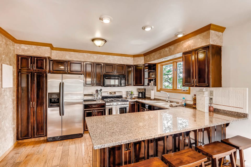 The kitchen has beautiful custom cabinetry and seating at the kitchen counter for 4 people.