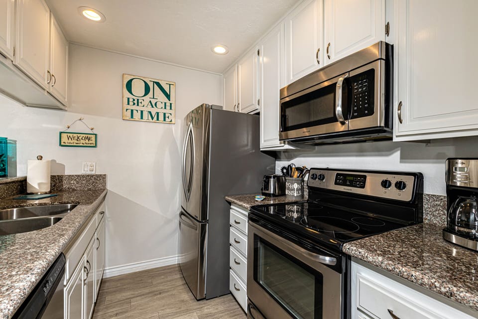 The chef's kitchen features stainless appliances, recessed lighting, a wood-look porcelain floor.